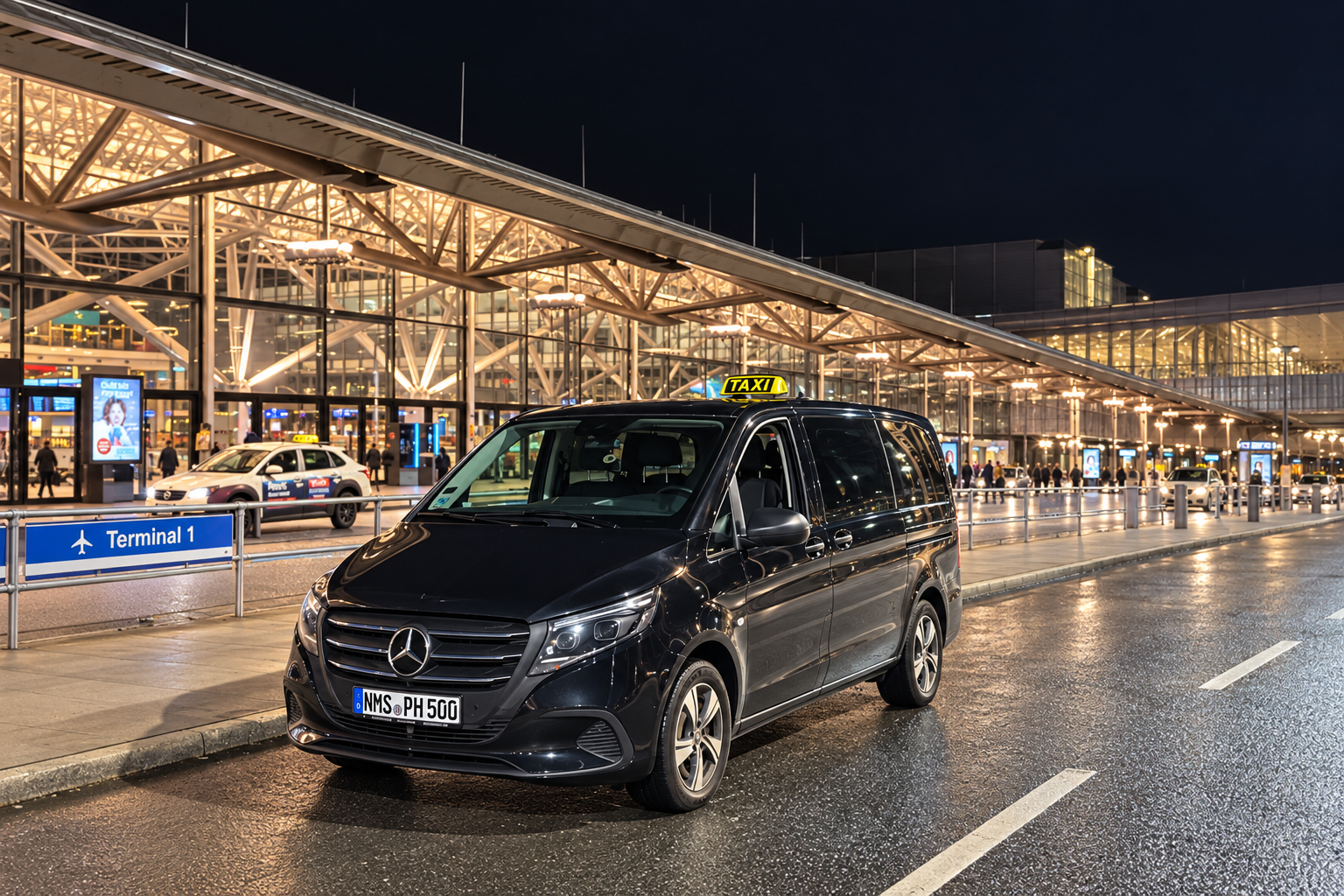 Unser Großraumtaxi vor dem beleuchteten Terminal am Hamburg Airport